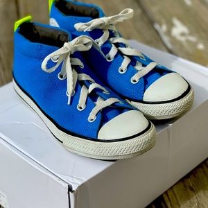 Boys Hightop Chuck Taylor’s in vibrant blue with neon yellow/green accent.
